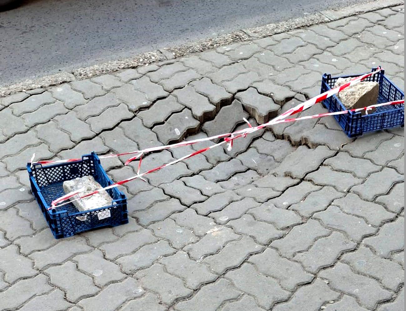 Trotuarul surpat de la Wimarkt, semnalizat corespunzător cu... lăzi din plastic și pietre