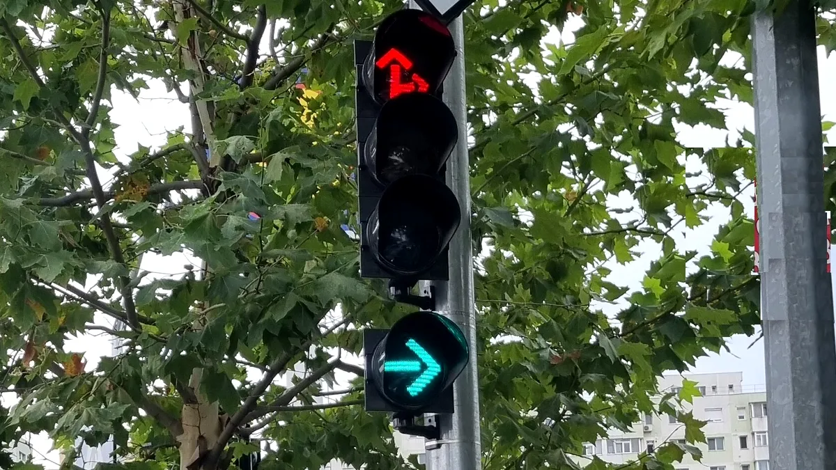 Mașina din față stă la semafor, deși este verde intermitent la dreapta. Este obligată să vireze? Ce spune legea